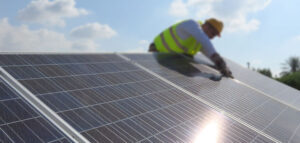 Image of person installing solar cells on a roof